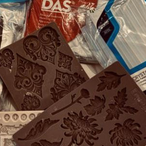 Chocolate mold with decorative patterns on a table with various items including a box of Das Riegel.