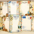 Collection of travel-themed stationery items including notebooks, stamps, and postcards on a light background.